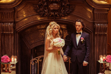 Fototapeta na wymiar Happy couple, bride & groom holding hands at luxury wedding cere
