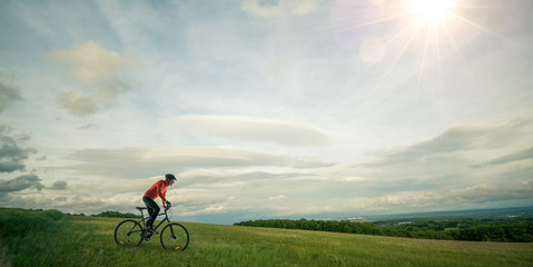 Fototapeta na wymiar Sportif cycliste en vélo tout chemin dans l'herbe