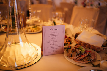 Romantic purple menu on wedding reception table closeup
