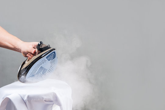 ironing / man irons white shirt
