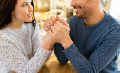 happy couple holding hands at restaurant or cafe