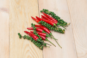 red chili pepper and green peppercorns on wood background , spicy healthy aroma herbal ingredient of Thai food.