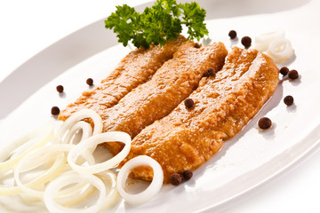 Marinated fried herring fillets on white background 