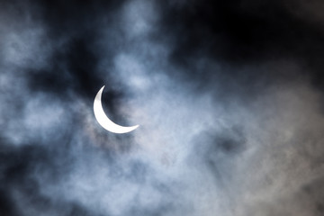 Obraz na płótnie Canvas Partial solar eclipse through clouds