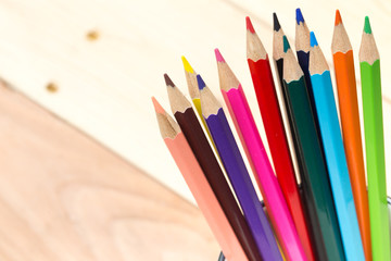 color pencils on wood table background, artist working space concept.