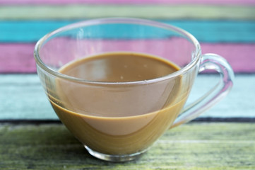 coffee cup on colorful wooden panel.
