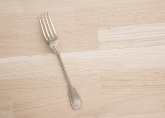 Silver fork lying on wooden table with copy space. Still life of vintage cutlery in kitchen....