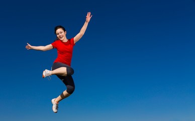 Fototapeta na wymiar Teenage girl jumping outdoor against blue sky