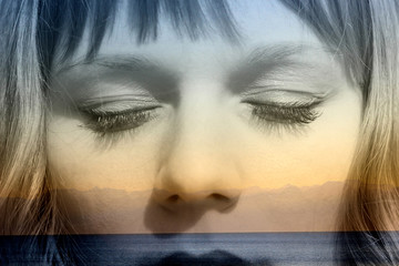 Double exposure of girl with closed eyes and seaside mountainscape