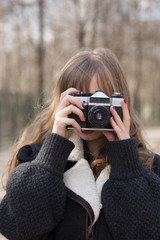 portrait of  pretty tourist taking photographs with vintage retro camera