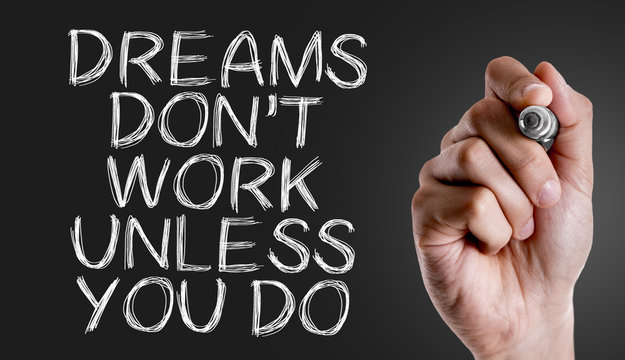 Hand writing the text: Dreams Don't Work Unless You Do
