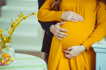 Man touches a belly of his pregnant woman