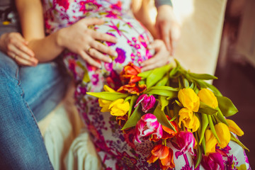 Obraz na płótnie Canvas Pregnant with a bunch of colorful tulips