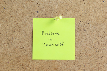 Believe In Yourself, written on an yellow sticky note on a cork board