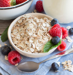 Rolled oats in a bowl with berries and milk