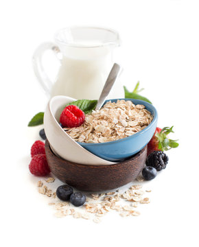 Rolled oats in a bowl with berries and milk
