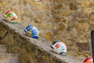 Colorful water pitcher in a row on a stone wall