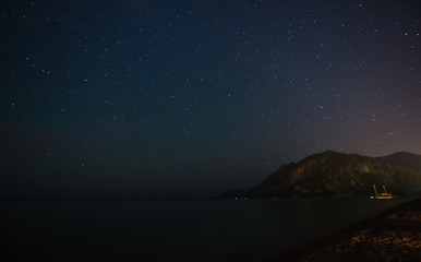 Fototapeta premium Night starry sky at the sea coast in Cirali, Turkey - landscape exterior.