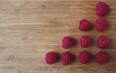 Raspberries on rustic natural wooden board