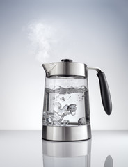 close up view of nice metal tea kettle on grey color background