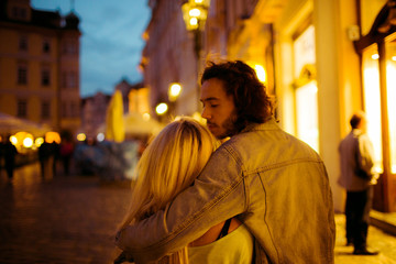 Obraz premium Romantic young couple walking & hugging in Prague street