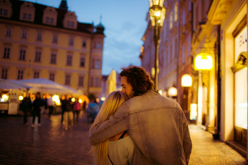 Romantic young couple walking & hugging in Prague street