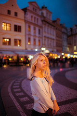 Fototapeta premium Beautful happy tourist blonde woman posing in evening Prague str