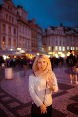 Beautful happy tourist blonde woman posing in evening Prague str