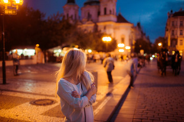 Beautful happy tourist blonde woman posing in evening Prague str