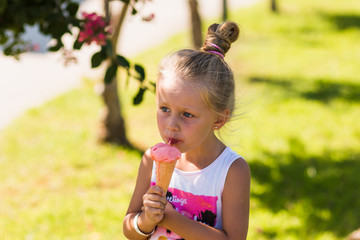 cute little girl eating ice cream in the summer sunny day
