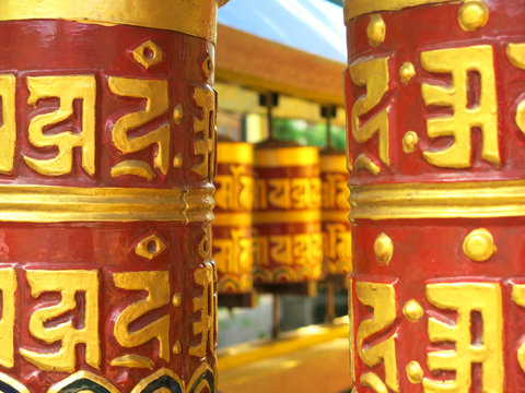 Buddhist praying wheels surround a tibetan temple..