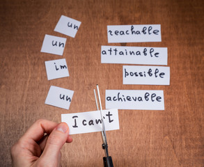 Self motivation concept. Negative words cut with scissors.