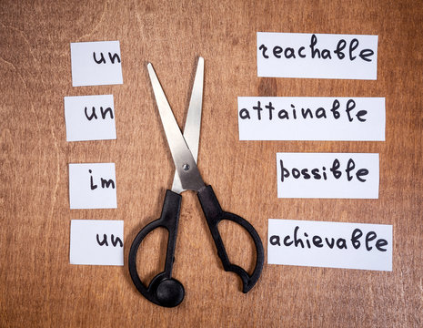 Self motivation concept. Negative words cut with scissors.