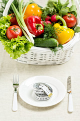 Concept of a healthy diet. The basket of vegetables and a plate