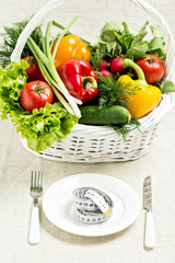 Concept of a healthy diet. The basket of vegetables and a plate