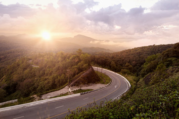 Picturesque landscape scene and sunrise above road