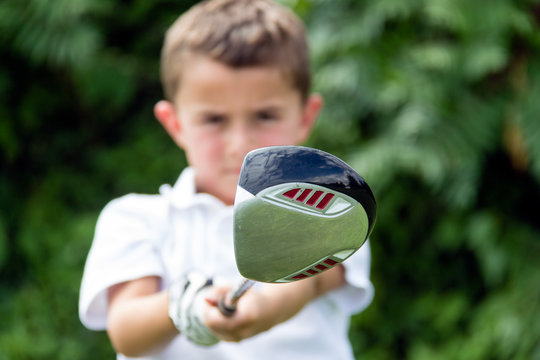 Close-up of golf driver club head held by little boy golfer - se