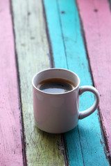 coffee cup on colorful wooden panel.