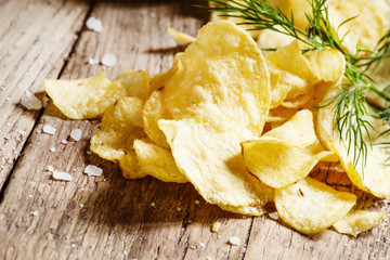 Salted potato chips with herbs on a wooden table vintage, countr