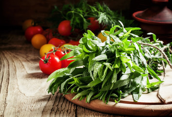 Fresh green tarragon, cherry tomatoes, vintage wooden background