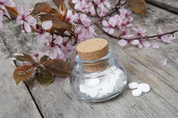 Schuessler Salze auf altem Tisch mit Kirschblüten