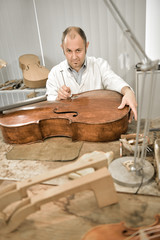 Artisan luthier working on the creation of violin.