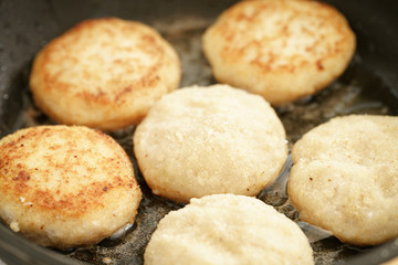 preparing fried fish cakes on pan, shallow focus