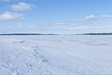 Fototapeta na wymiar View of frozen northern lake on a clear winter day 