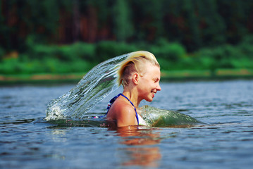 Beauty Model Girl Splashing Water with her Hair . Beautiful Woman in Water