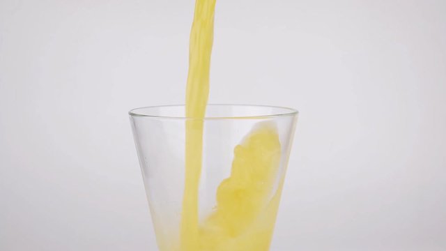Orange juice pouring in glass