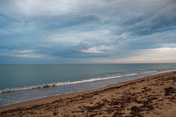 Dramatic sky with cumulus clouds over the beach. Landscapes