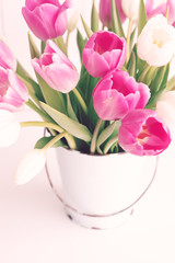 Pink and white tulips in a vintage white tin bucket