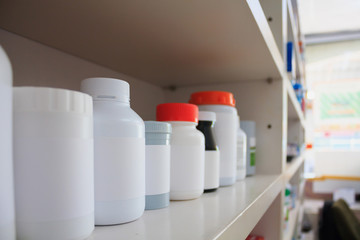 medicine bottles arranged on shelf at drugstore