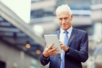 Senior businessman holding touchpad 